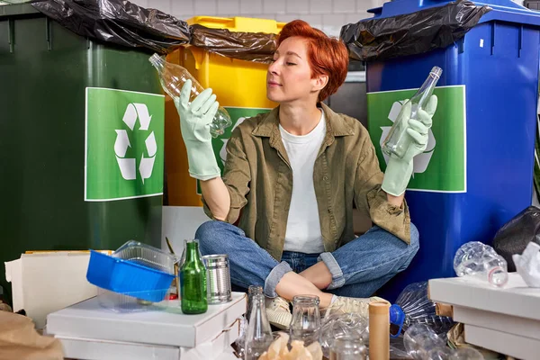 Feminino triagem de lixo na lata de lixo. Mulher está jogando fora garrafas — Fotografia de Stock