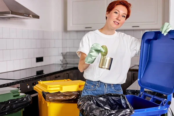 Çevre dostu genç bir kadın teneke kutuyu çöp kutusuna atar, yan görünüm portresi — Stok fotoğraf