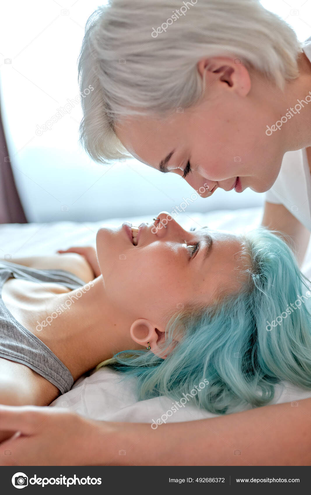Visão lateral sobre as mulheres no conceito de amor.Jovens duas lindas  namoradas fazendo amor na cama fotos, imagens de © romanchazov27 #492686372