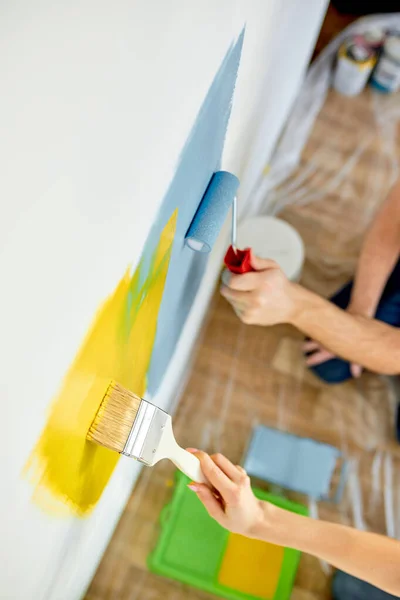 Jovens pintando paredes em casa nova, usando rolo de pintura, escova, close-up foto — Fotografia de Stock