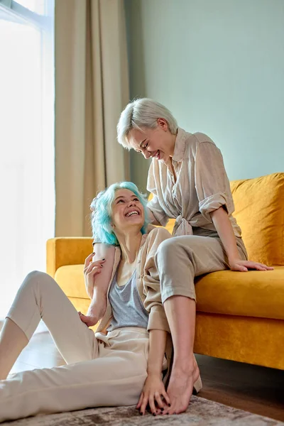 Retrato de casal lésbico feliz se divertindo no quarto acolhedor brilhante juntos. Conceito LGBT. — Fotografia de Stock