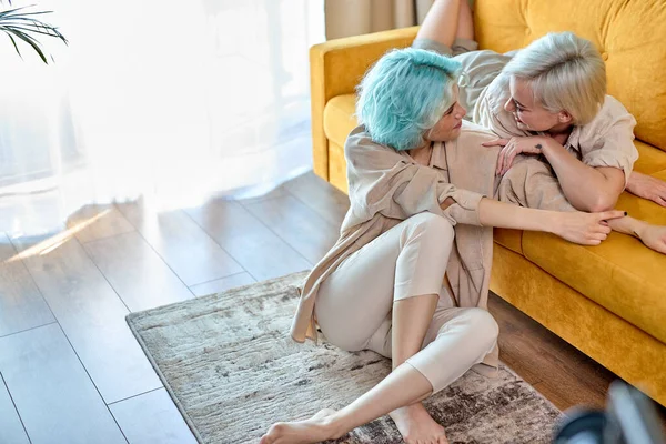 Adorable jeune couple lesbien flirtant à la maison, amoureux, parlant, vue de côté portrait — Photo