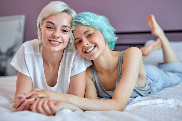 Two relaxed positive women, female friends on bed. Couple in love hugging. LGBT — Stock Photo, Image