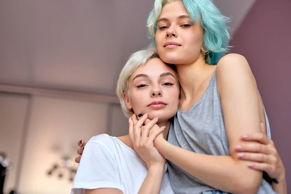 Relaxed lesbian couple embracing on bed and looking at camera. homosexual couple — Stock Photo, Image