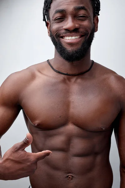 Θετική χαμογελαστός Αφρικανός bodybuilder δείχνει σε κοιλιακούς, shirtless μυϊκό σώμα — Φωτογραφία Αρχείου