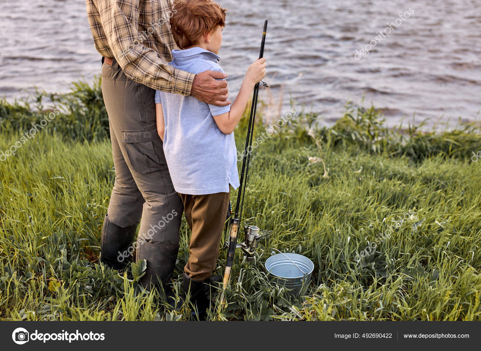 Granddadr and grandson came to fish family in lake fishing rods, looking at  side — Stock Photo © romanchazov27 #492690422