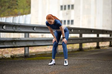 Koştuktan, koştuktan, dinlendikten sonra yorgun düşmüş genç bir kadın.