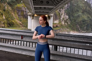 Spor salonundaki kadın koşucu açık hava koşusundan sonra dinleniyor.