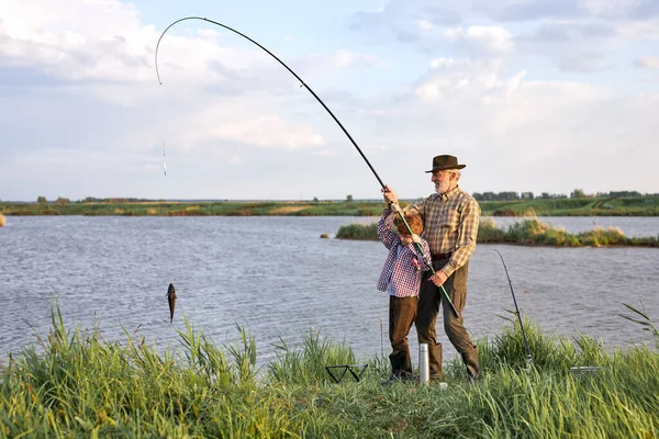 Felice uomo maturo con ragazzo adolescente pescare pesce sul lago, In campagna, Felice — Foto Stock