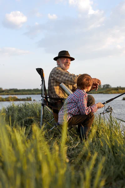 Avô idoso e neto jogando pesca enfrentar em ambiente natural — Fotografia de Stock