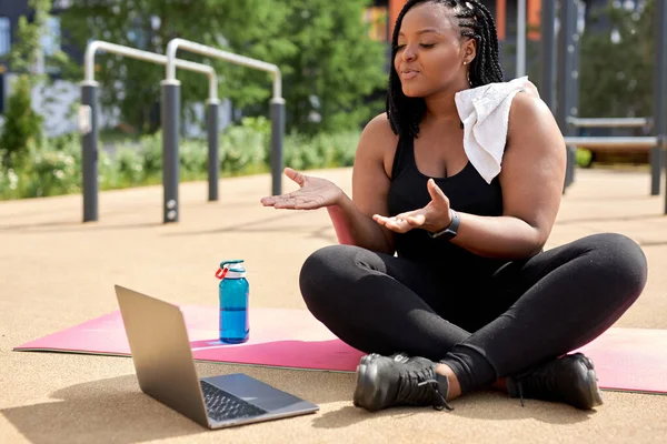 Şişman Afrikalı kadın dışarıda bilgisayarla online antrenman yapıyor. Çevrimiçi fitness — Stok fotoğraf