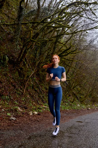 走ってる女。森の中でジョギングするランナー。白人女性が屋外で訓練し — ストック写真