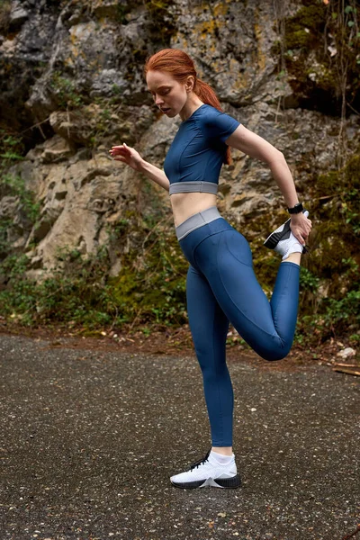 Πλάγια άποψη πλήρους μήκους πορτρέτο της γυμναστικής κυρία τεντώνει τα πόδια, προθέρμανση των μυών — Φωτογραφία Αρχείου