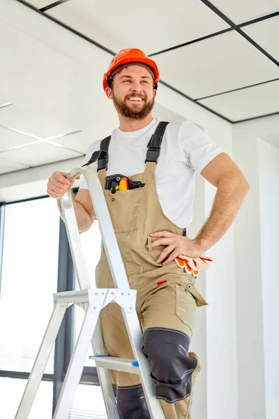 Reparação de quartos. Construtor confiante caucasiano reparar teto, de pé na escada rolante — Fotografia de Stock