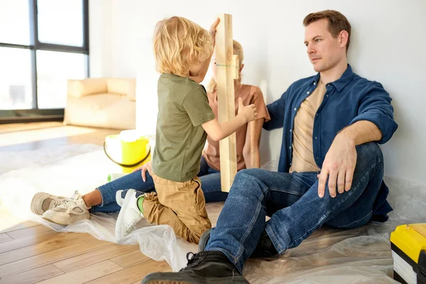 Tempo de família. Família agradável tem descanso após a renovação do reparo em casa, enquanto o filho se divertir, conversar — Fotografia de Stock