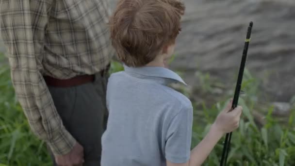 Cropped Senior nice man and little caucasian redhead boy together at the pond — Stock Video