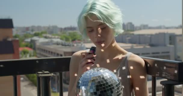 Úžasná žena s krátkými zelenými vlasy kouření elektronické páry cigarety na balkóně — Stock video