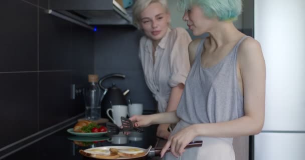 Twee lesbische vriendinnen maken maaltijd in de keuken in de ochtend, met praten en plezier — Stockvideo