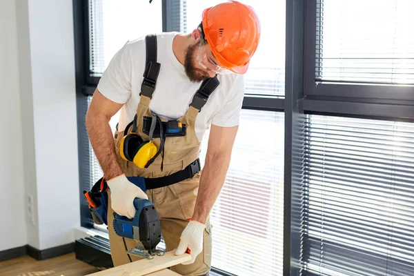 Homem trabalhando como faz-tudo, montando mesa de madeira com equipamentos, conceito para casa diy — Fotografia de Stock