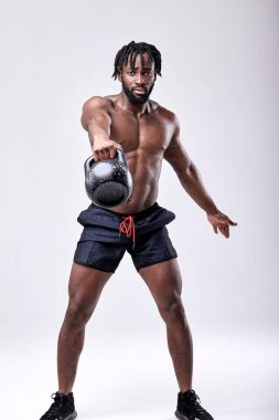 Çapraz antrenman. Afrikalı sporcu kettlebell kaldırarak ağırlık çalışması yapıyor.