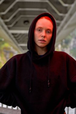 Hoş, sakin, kızıl saçlı Avrupalı kadın, dışarıda poz veren siyah kazak giyiyor.