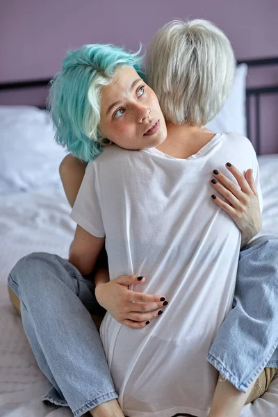 Melancholijna młoda lesbijska para obejmująca się w łóżku, przytulanie, w miłości, w przytulnej sypialni — Zdjęcie stockowe