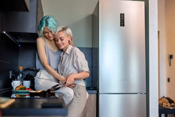 Izgalmas leszbikus lgbtq pár szerelmes ölelés, nevetés, miközben főzés a konyhában otthon — Stock Fotó