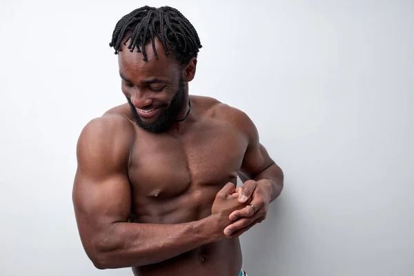 Homem positivo com belo tronco mostrando braços bíceps, isolado em fundo branco — Fotografia de Stock