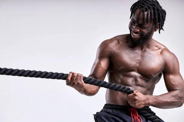 Homem muscular africano atraente trabalhando com cordas pesadas. isolado em fundo branco — Fotografia de Stock