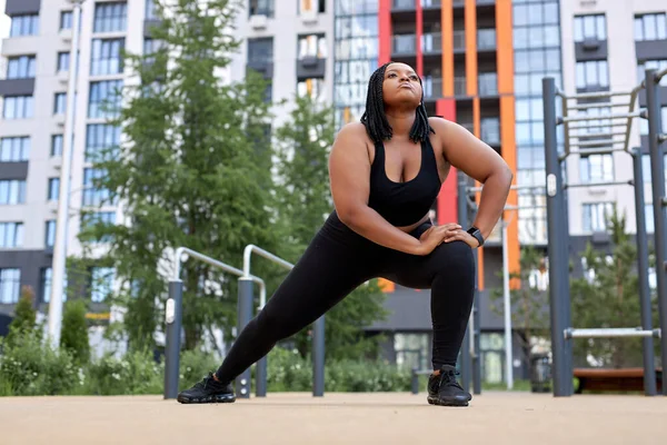 Konsantre olmuş Afro-Amerikan kadın yazın şehirde hamleler yapıyor, açık havada antrenman yapıyor.. — Stok fotoğraf