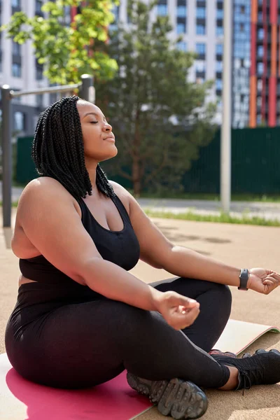 Güzel görünümlü Afrikalı kadın dışarıda meditasyon yapıyor, sakin ol, yoga yapıyor. — Stok fotoğraf