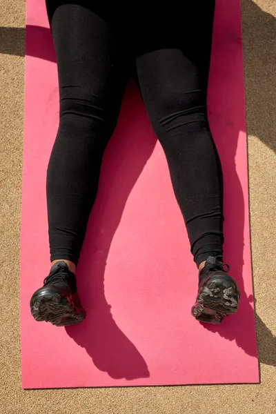 Top View On Fat Female Legs In Sportive Clothes Lying On Pink Fitness Mat — Stock Photo, Image