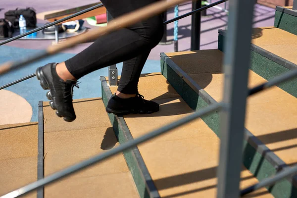 Cropped african woman running up stairs with concentrated motivated expression — Stock Photo, Image