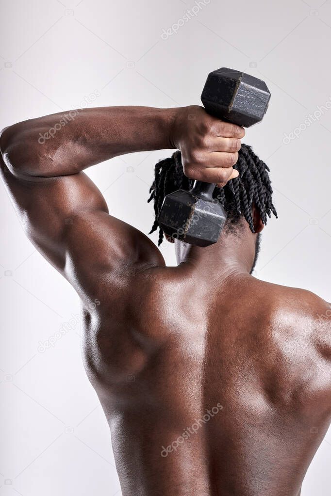 Unrecognizable muscular man on white studio background. Bodybuilding and fitness concept