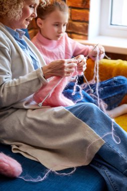 Yeni yetenekler. Hoş, hoş, yaşlı bir kadın, çalışkan kızına örgü örmeyi öğretiyor.