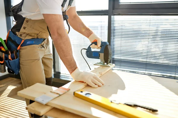 Carpintero de cerca trabajando en madera con rompecabezas eléctrico en una casa nueva. Trabajos de carpintería —  Fotos de Stock