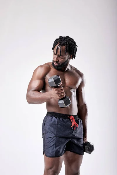 Nagyon erős fiatal srác testépítő afrikai megjelenés csinál gyakorlatokat — Stock Fotó