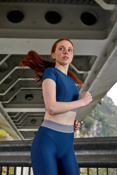 Φοβερό αυτοπεποίθηση σπορ γυναίκα στο κομψό αθλητικό φόρεμα τζόκινγκ στη γέφυρα — Φωτογραφία Αρχείου