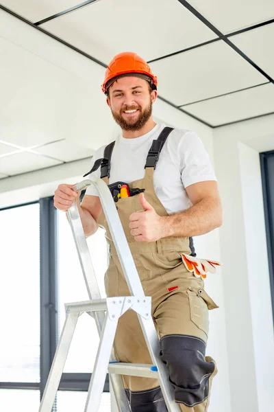 Builder escalada escada rolante fazendo renovação da casa. trabalhador da construção em capacete de segurança — Fotografia de Stock