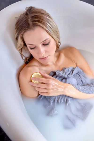 Vista dall'alto ritratto di bionda caucasica signora sdraiata in bagno toccare la pelle con fetta di limone — Foto Stock