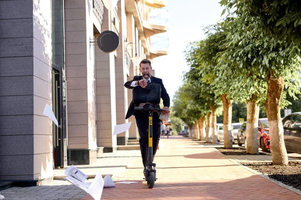 Caucasian businessman riding electric scooter when hurrying to work in the morning — Stock Photo, Image