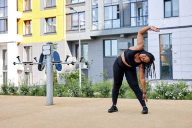 Kilolu genç bir kadın spor alanında antrenman yapıyor. Obez bir dişinin eğimi var.