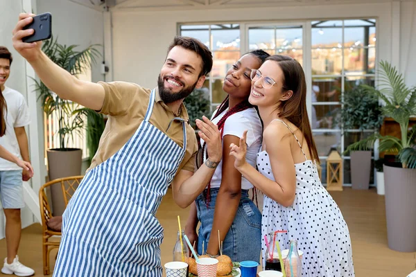 Genç mutlu insanlar terasta barbekü partisi veriyor, birlikte selfie çekiyorlar. — Stok fotoğraf