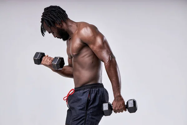 Guapo macho con torso desnudo haciendo ejercicios con pesas, practicando deporte —  Fotos de Stock