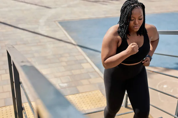 Obese young african woman foing fitness exercises on stairs outdoors. weight loss — Stock Photo, Image