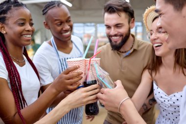 Dışarıda limonatayla piknik yapan heyecanlı arkadaşlar. Gençler içiyor.
