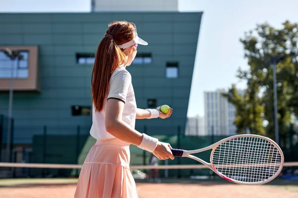 Πίσω όψη για λεπτή λεπτή νεαρή γυναίκα σε σέξι αθλητικά παίζοντας τένις στο πάρκο της πόλης — Φωτογραφία Αρχείου