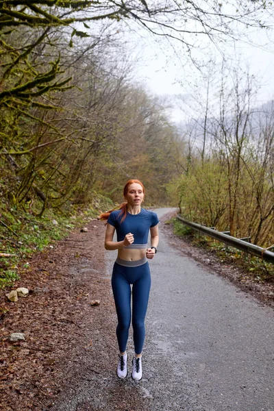 走ってる女。森の中でジョギングするランナー。白人女性が屋外で訓練し — ストック写真