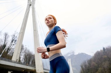 Kendine güvenen kadın koşucuya bak. Hareket halinde, yana bakıyor.