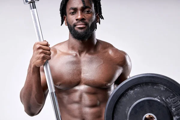 Barbudo africano muscular cara segurando barbell peso, equipamento desportivo, olhar para a câmera — Fotografia de Stock